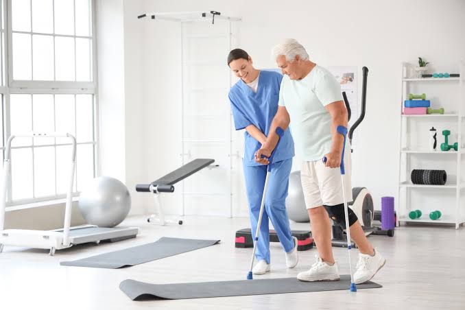 Physical therapist helping middle-aged adult improve mobility