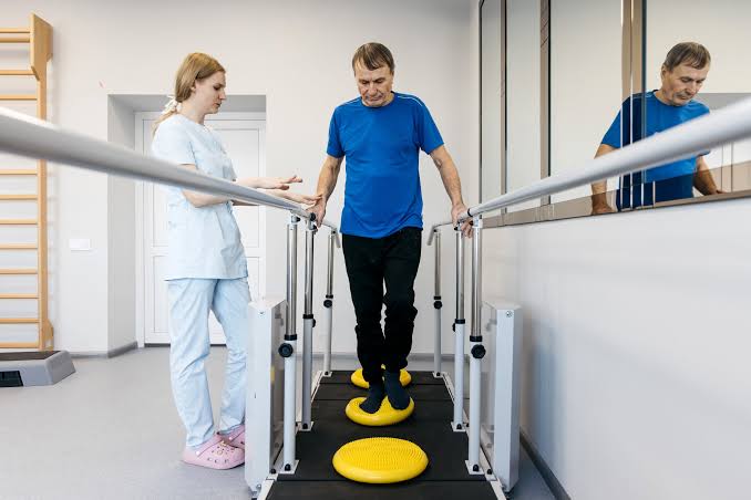 Physical therapist guiding a patient through rehabilitation exercises