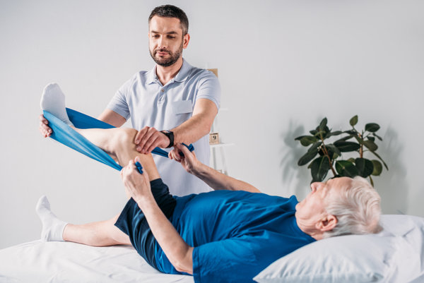 Patient recovering after hip replacement surgery with a physical therapist